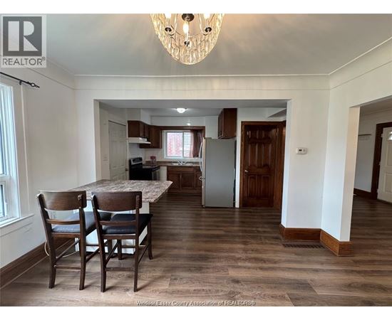 A dining room with a table and chairs.