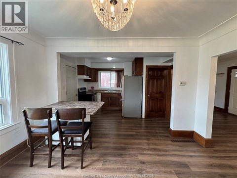 A dining room with a table and chairs.