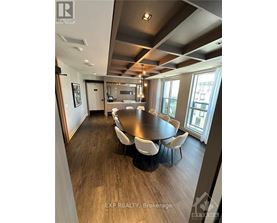 A dining room with a large table and chairs.