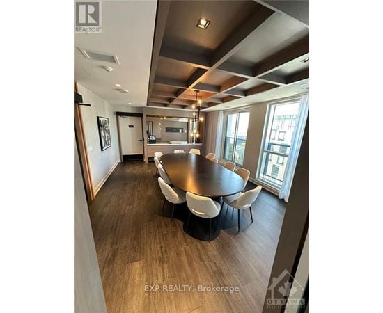 A dining room with a large table and chairs.