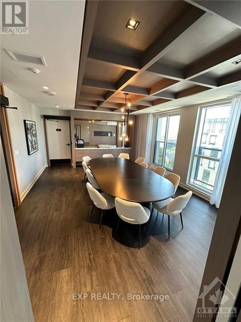 A dining room with a large table and chairs.