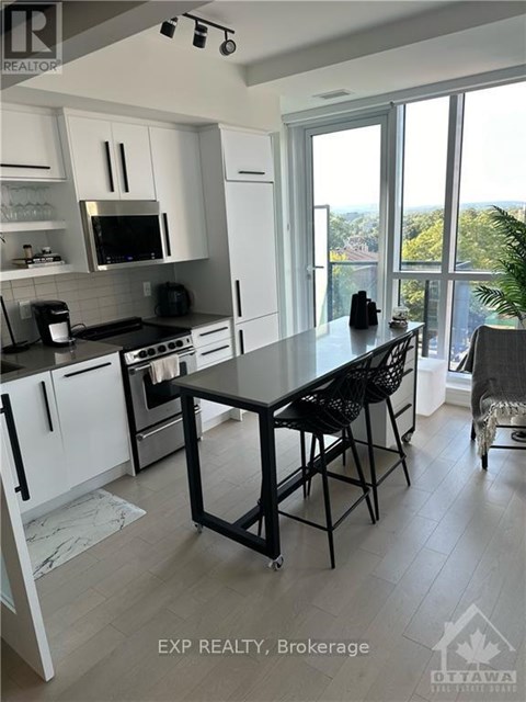 A kitchen with a table and chairs in front of a window.