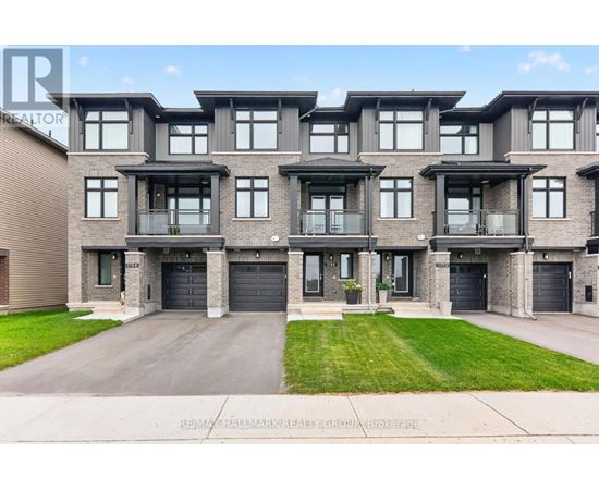 A modern apartment building with a large front yard and a driveway.