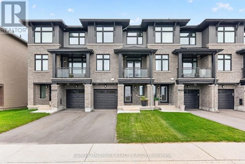 A modern apartment building with a large front yard and a driveway.