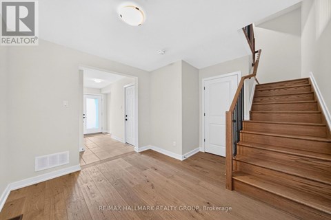 A spacious hallway with wooden floors and a staircase.