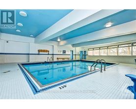 A large indoor swimming pool with a blue tiled floor.