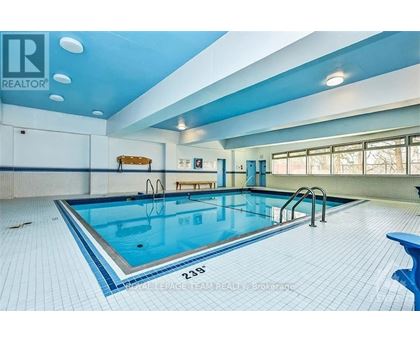 A large indoor swimming pool with a blue tiled floor.
