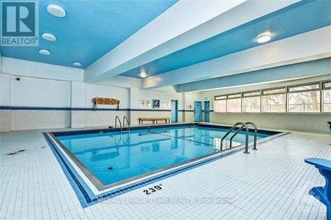 A large indoor swimming pool with a blue tiled floor.