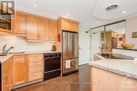 A modern kitchen with wooden cabinets and stainless steel appliances.