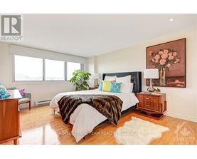 A bedroom with a large bed and a painting on the wall.
