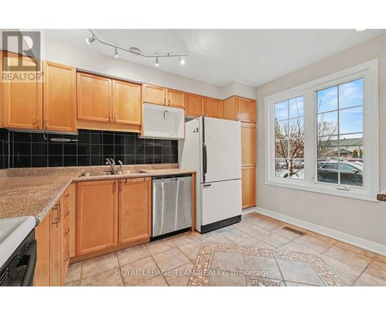 A kitchen with wooden cabinets and a black tile backsplash.