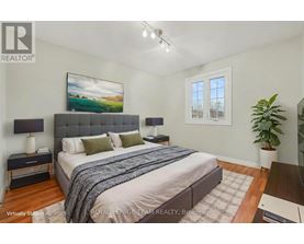 A bedroom with a large bed and a painting on the wall.