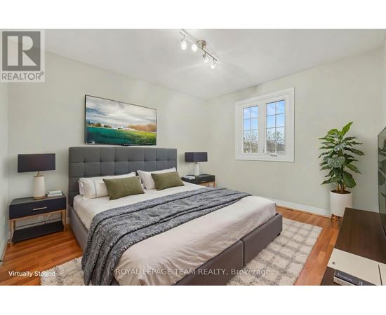 A bedroom with a large bed and a painting on the wall.