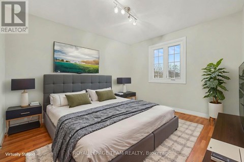 A bedroom with a large bed and a painting on the wall.