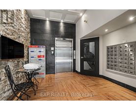 A kitchen area with a table and chairs, a fridge, and a wall of mailboxes.