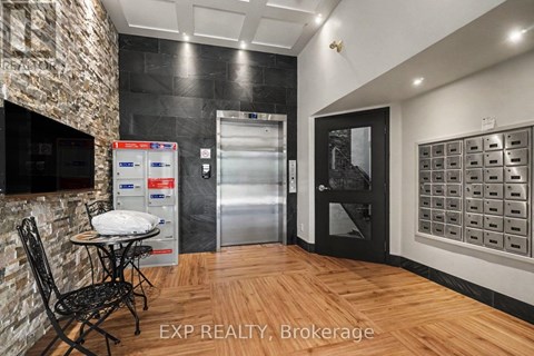 A kitchen area with a table and chairs, a fridge, and a wall of mailboxes.