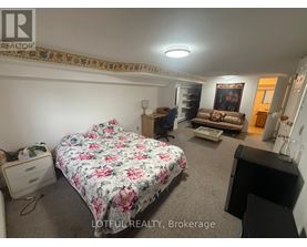 A bedroom with a floral bedspread and a bed in the center of the room.