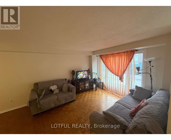 A living room with a grey couch and a television.