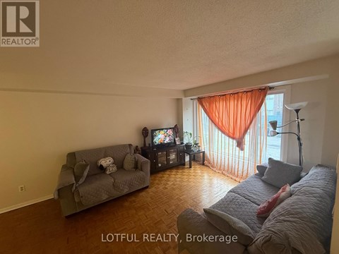 A living room with a grey couch and a television.
