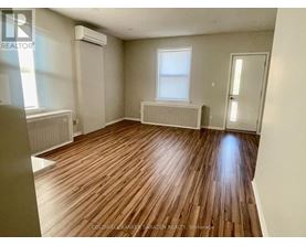 A room with wooden flooring and a window.
