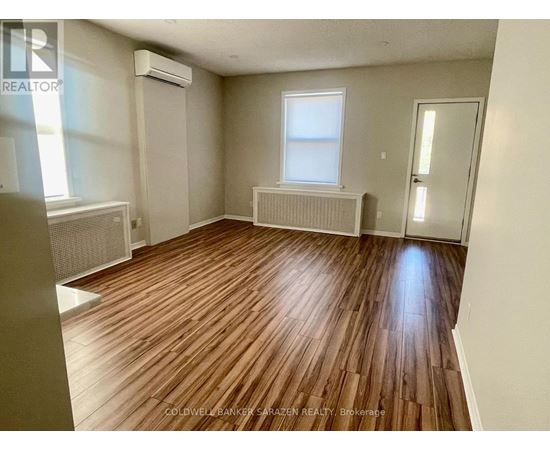 A room with wooden flooring and a window.