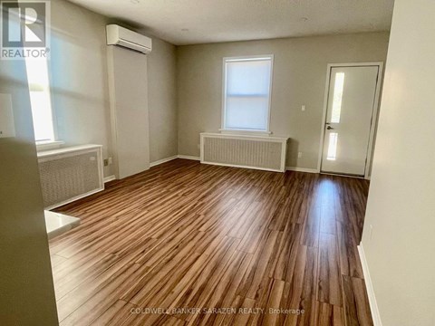 A room with wooden flooring and a window.