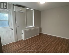 A room with a window, door, and air conditioner unit.