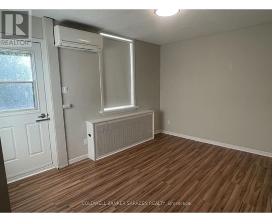 A room with a window, door, and air conditioner unit.