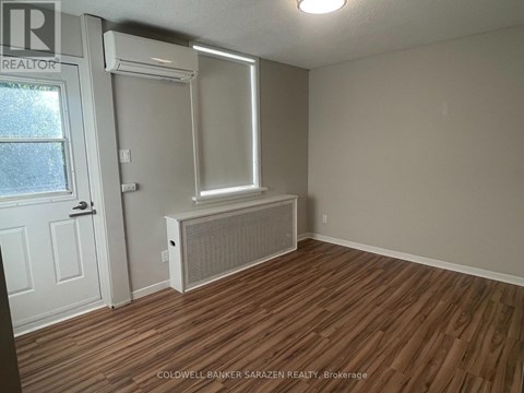 A room with a window, door, and air conditioner unit.