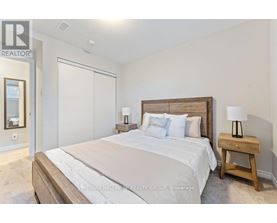 A bedroom with a large bed and a wooden nightstand.