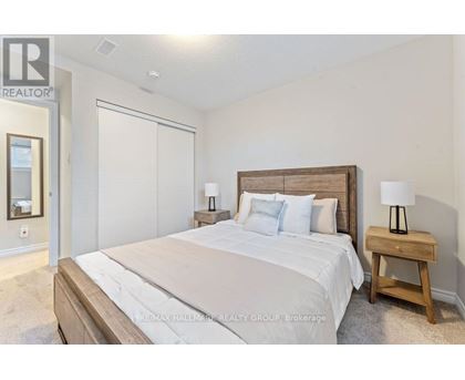 A bedroom with a large bed and a wooden nightstand.