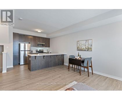 A kitchen with a dining table and chairs in the foreground.