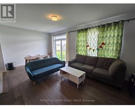 A living room with a blue couch, a white coffee table, and a window with curtains.