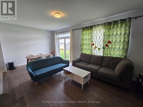A living room with a blue couch, a white coffee table, and a window with curtains.