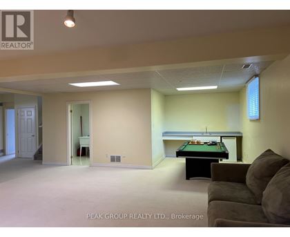 A room with a pool table and a couch.