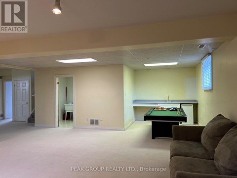 A room with a pool table and a couch.