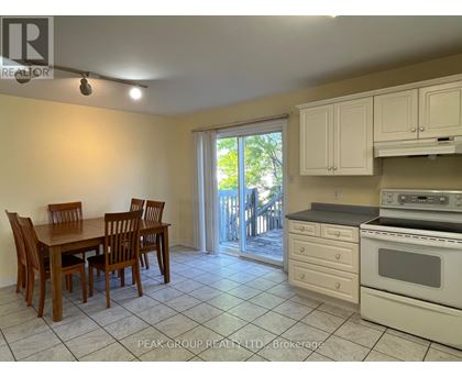 A kitchen with a table and chairs and a stove top oven.