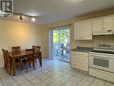 A kitchen with a table and chairs and a stove top oven.