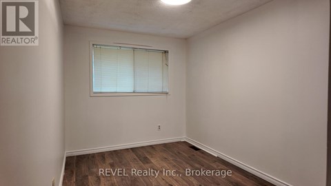 A room with a window and a wooden floor.