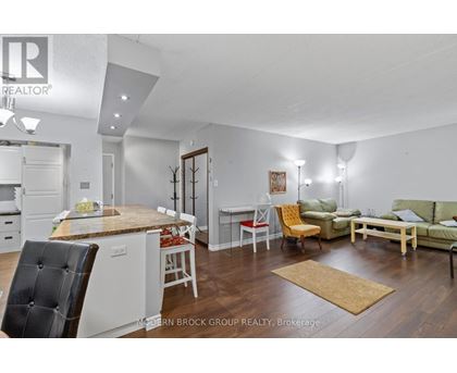 A well-lit, modern kitchen and living room with a dining table and chairs.