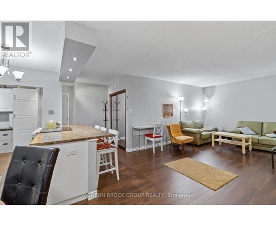 A well-lit, modern kitchen and living room with a dining table and chairs.