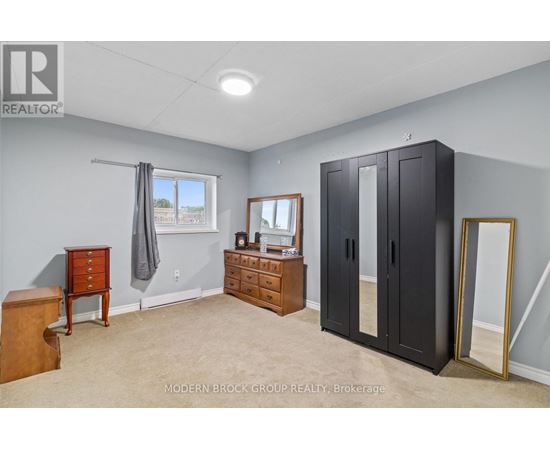 A bedroom with a dresser, mirror, and wardrobe.