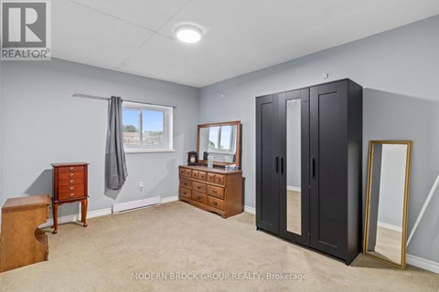 A bedroom with a dresser, mirror, and wardrobe.