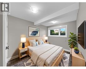 A bedroom with a bed, nightstands, and a window.