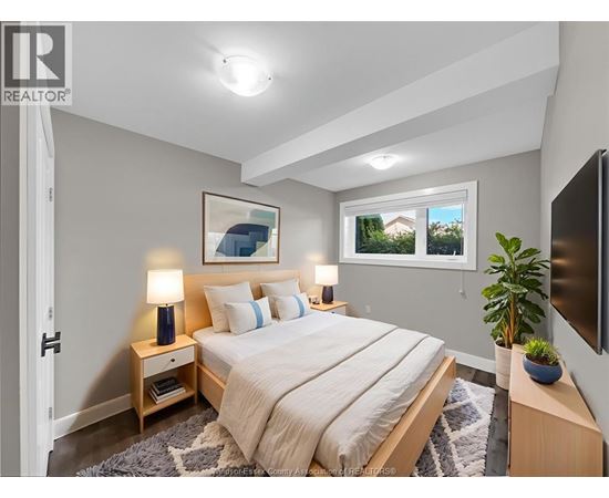 A bedroom with a bed, nightstands, and a window.
