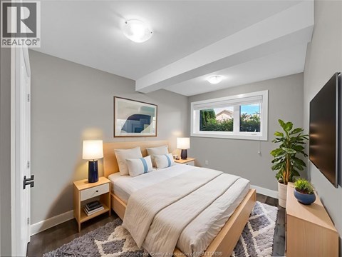 A bedroom with a bed, nightstands, and a window.