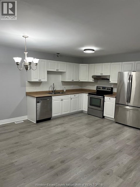 A kitchen with white cabinets and a wooden island.