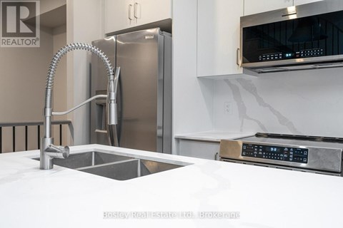 A modern kitchen with a stainless steel refrigerator and a white countertop.