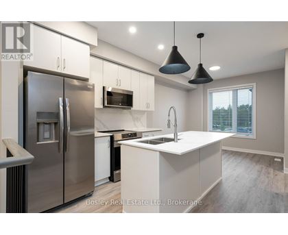 A modern kitchen with a stainless steel refrigerator and white countertops.