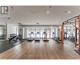 A gym with a variety of equipment including treadmills, weights, and exercise machines.